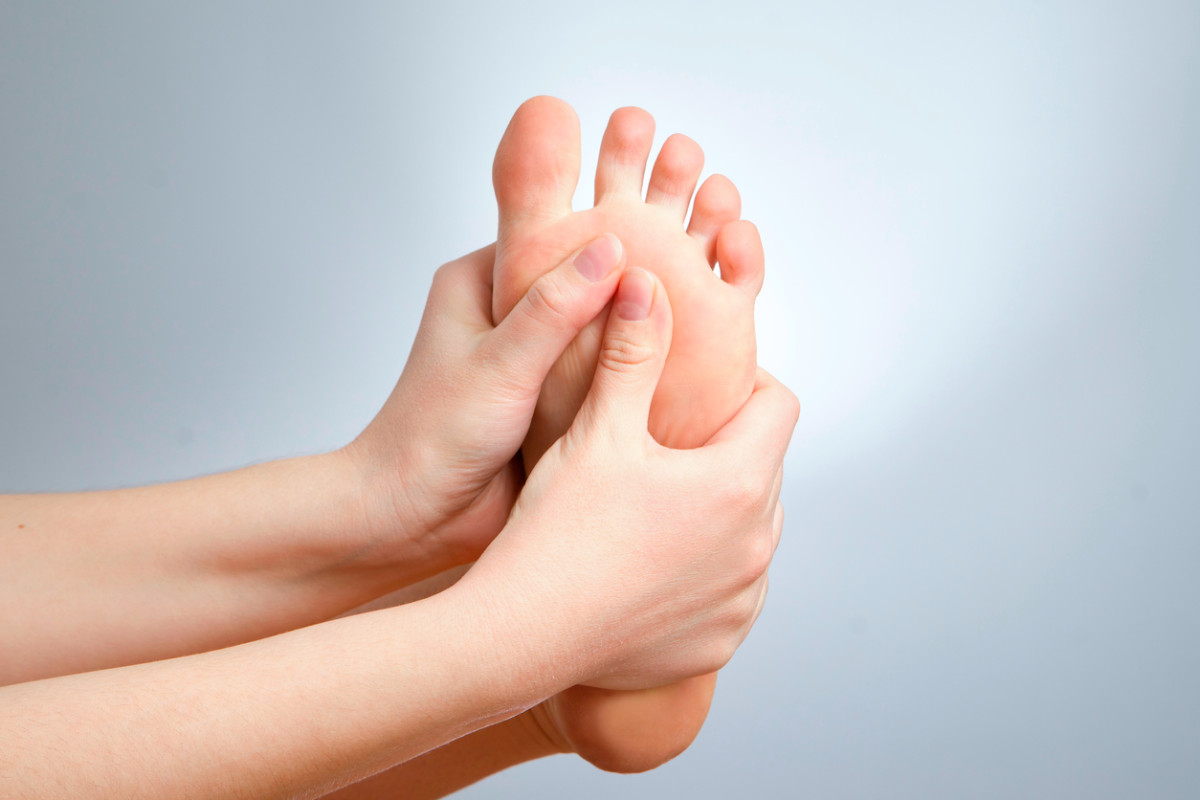 Person massaging foot as a mobility exercise for heel pain